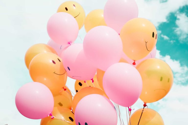 Luftballons mit fröhlichen und traurigen Gesichtern